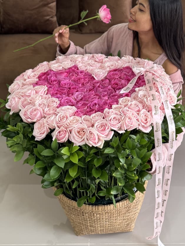 A luxurious heart-shaped basket arrangement of 171 pink and candy Holland roses