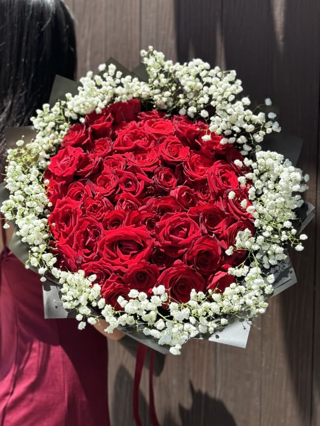A lavish bouquet of 51 red Holland roses with baby's breath