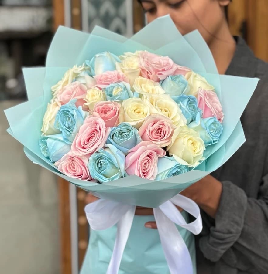 A beautiful arrangement of pastel roses in blue, pink, and cream, creating a soft and dreamy look.